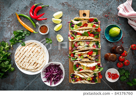 Chicken tacos with grilled meat, avocado, fresh vegetable salad and sauce salsa Chicken tacos with grilled meat, avocado, fresh vegetable salad and sauce salsa 84376760