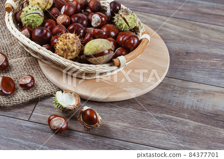 Close up view of Chestnuts in a basket on a wooden background 84377701
