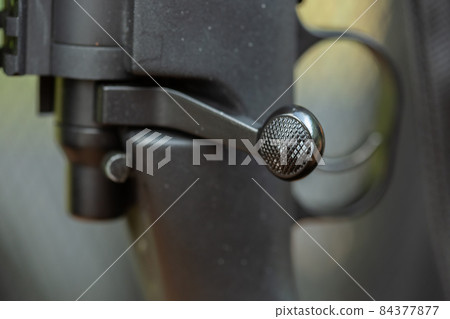 Close-up parts of automatic weapon with selective focus and blurred background Close-up parts of automatic weapon with selective focus and blurred background 84377877