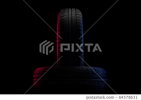 tires with a tread for winter driving on a black background with an image of red-blue illumination tires with a tread for winter driving on a black background with an image of red-blue illumination 84378631
