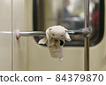 White toy kitten on the handrail in the subway. The child plays everywhere. Somebody lost it. It's suitable for greeting card design, postcard template. 84379870
