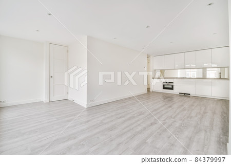 Interior of empty home kitchen with contemporary appliances. A large studio apartment with kitchen and white walls 84379997