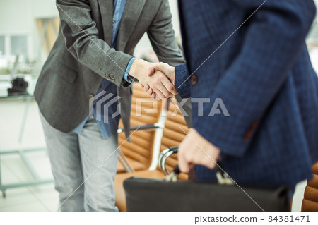 employees of the company with briefcases shaking hands in the lobby of a modern office employees of the company with briefcases shaking hands in the lobby of a modern office 84381471