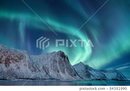 Aurora borealis in Norway. Green northern lights above mountains. 84381990