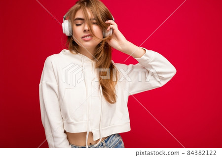 Photo of beautiful happy positive cool young blonde woman wearing white hoodie isolated over 84382122