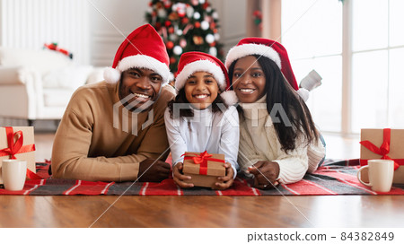 Portrait of happy black family in santa hants celebrating xmas Portrait of happy black family in santa hants celebrating xmas 84382849
