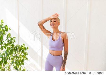 Relax after exercise, catch your breath. Tired young woman in sportswear wiping sweat from forehead, taking break 84382888