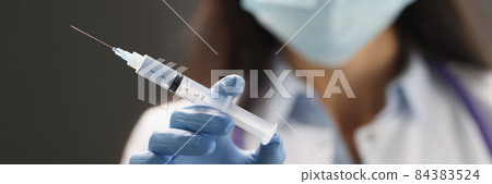 Doctor hand in blue gloves holds vaccine closeup Doctor hand in blue gloves holds vaccine closeup 84383524