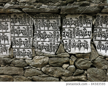 Mani wall, buddhist mantra carved in stones. 84383593