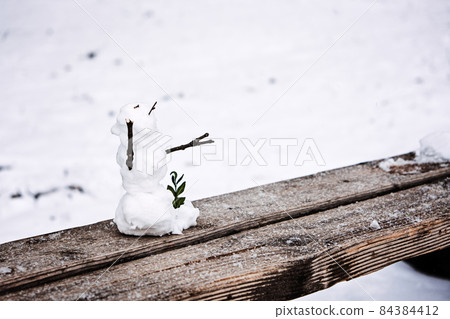 Little snowman on bench in Off-season Winter abandoned amusement park empty and covered in snow. Mind mental health winter, Seasonal Affective Disorder SAD during winter months. 84384412