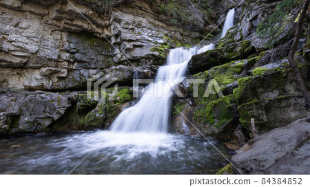Small cascade waterfall hidden in a forest, Canadian Rockies, Canada Small cascade waterfall hidden in a forest, Canadian Rockies, Canada 84384852