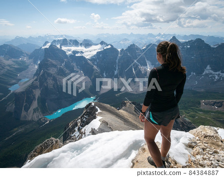 Female hiker looking on Moraine Lake from summit of Mount Temple, Banff, Canadian Rockies, Canada 84384887
