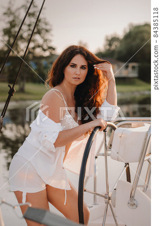 sexy woman in a white shirt enjoys the sunset on her private white yacht sexy woman in a white shirt enjoys the sunset on her private white yacht 84385118