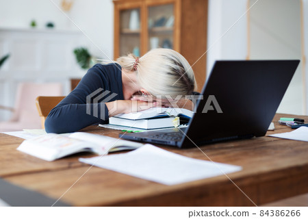 Female student preparing for exams and has her head resting on books. Female student preparing for exams and has her head resting on books. 84386266