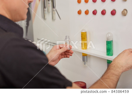 Male hairdresser choosing haircare products at beauty salon Male hairdresser choosing haircare products at beauty salon 84386459