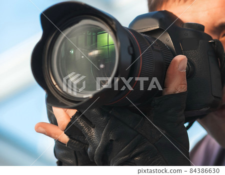professional photographer taking a picture on the camera. professional photographer taking a picture on the camera. 84386630