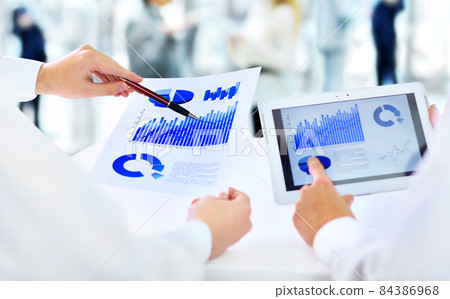 Close-up of businessman explaining a financial plan to colleagues at meeting Close-up of businessman explaining a financial plan to colleagues at meeting 84386968