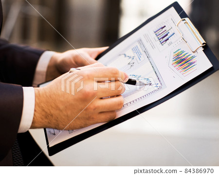 Close-up of female and male hands pointing at business document while discussing it 84386970