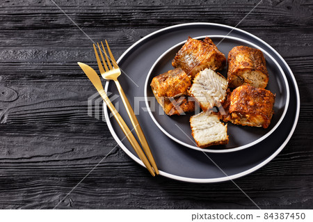 fried pieces of hake on a plate 84387450