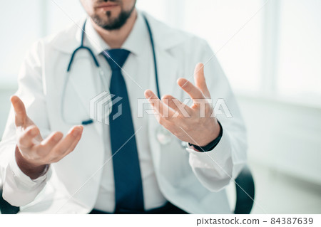 male doctor explaining something to his patient. 84387639
