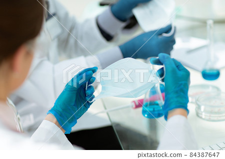 close up. female scientist putting on a protective mask . 84387647