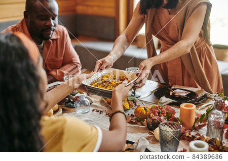 Interracial girl helping her mother while taking bowl with homemade food Interracial girl helping her mother while taking bowl with homemade food 84389686