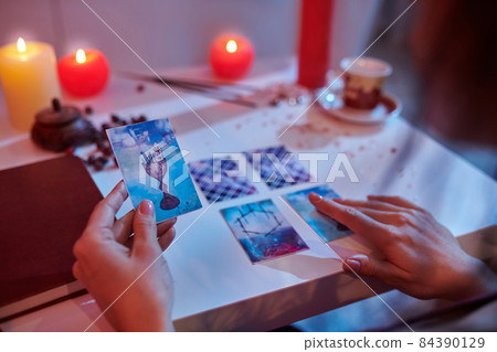 Experienced fortune-teller reading cards laid out on the divination table 84390129