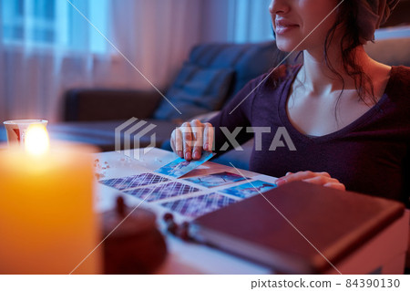 Dark-haired Caucasian soothsayer laying out Tarot cards 84390130
