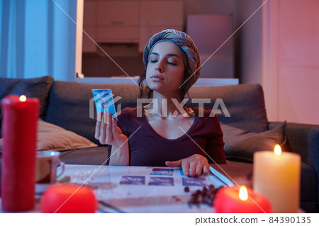 Dark-haired Caucasian soothsayer focused on her divination Dark-haired Caucasian soothsayer focused on her divination 84390135