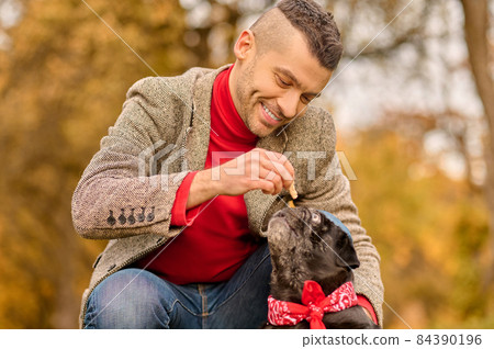 A young man with his pet in the autumn park 84390196