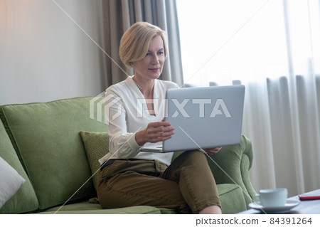 Businesswoman working from home and looking involved 84391264