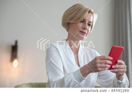 Blonde woman with a smartphone in hands Blonde woman with a smartphone in hands 84391269