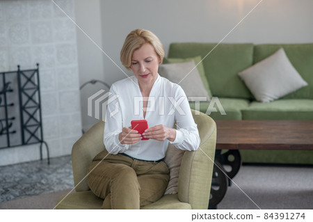 Blonde woman with a smartphone in hands Blonde woman with a smartphone in hands 84391274