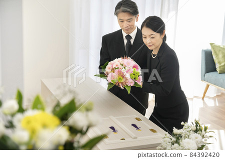 中年男女向棺材獻花束 家庭殯儀館葬禮形象 中年男女向棺材獻花束 家庭殯儀館葬禮形象 84392420