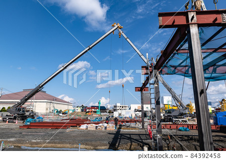 Lifting work by a self-propelled mobile crane at a construction site in an urban area 84392458