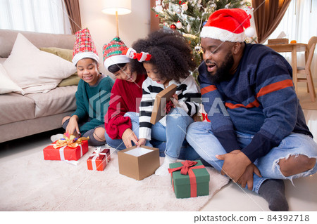 Happy family father and mother giving gift box with daughter on celebration in Christmas day. Happy family father and mother giving gift box with daughter on celebration in Christmas day. 84392718
