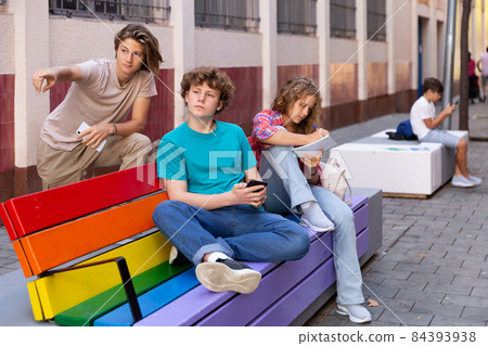 Group of teengers on bench Group of teengers on bench 84393938