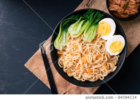Korean spicy instant noodles soup with bok choy and boiled egg in a bowl eating with kimchi Korean spicy instant noodles soup with bok choy and boiled egg in a bowl eating with kimchi 84394114