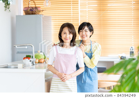 Parent and child standing in the kitchen Parent and child standing in the kitchen 84394249