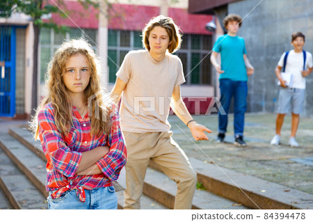 Sad young girl offended by her friends near school outdoors 84394478