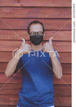 asian man wearing face protection mask raising good thumb sign 84395483
