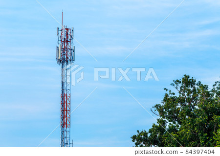 Mobile station receiver antenna tower with fluffy clouds blue sky daylight background. 84397404
