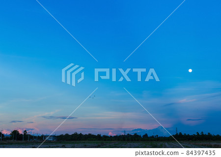 dusk Twilight blue bright dramatic sunset sky and moon in countryside or beach colorful cloudscape texture with white clouds air background. 84397435