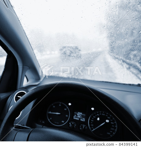 Dangerous winter season with snow on the road. The interior of the car from the driver's point of view - dangerous traffic in bad weather. Dangerous winter season with snow on the road. The interior of the car from the driver's point of view - dangerous traffic in bad weather. 84399141