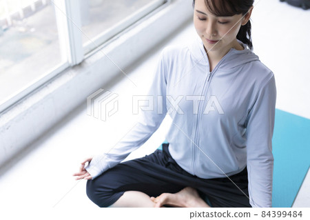 在窗邊冥想的年輕女人 84399484