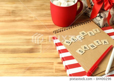 Secret Santa and Christmas composition on wooden background 84400296