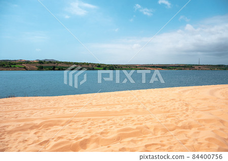 Desert dune and blue river on sunny day Desert dune and blue river on sunny day 84400756