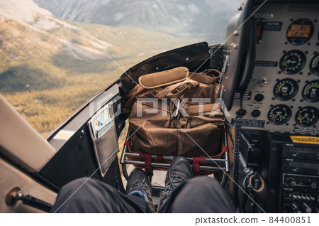 Inside of cockpit a helicopter flying over Rocky mountains 84400851