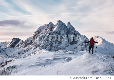 Mountaineer standing on Segla mountain with majestic snowy mount on winter at Senja island 84400864