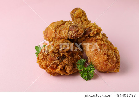 Tasty fried chicken on pink background, close up 84401788